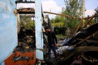 Locals inspect the house hit by a rocket during the fighting over the breakaway region of Nagorno-Karabakh, in the village of Baharli