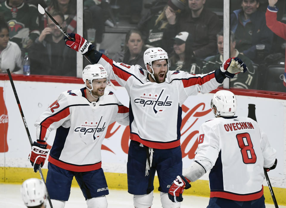 Washington Capitals' Evgeny Kuznetsov (92), of Russia, Tom Wilson (43) and Alex Ovechkin (8), of Russia, celebrate a goal by Wilson against the Minnesota Wild during the third period of an NHL hockey game, Sunday, March 1, 2020, in St. Paul, Minn. The Capitals won 4-3. (AP Photo/Hannah Foslien)