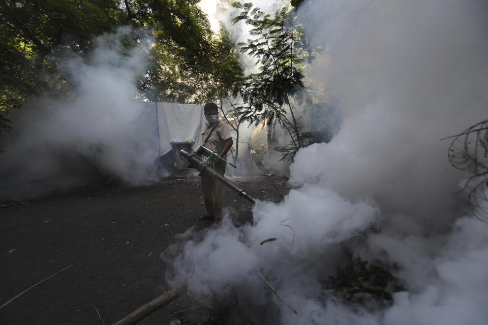 A Mumbai Municipal Corp. worker fumigates a street in Mumbai, India, Wednesday, June 10, 2020. While 2019 was the worst year on record for global dengue cases, experts fear an even bigger surge is possible because their efforts to combat it were hampered by restrictions imposed during the coronavirus pandemic. (AP Photo/Rafiq Maqbool)