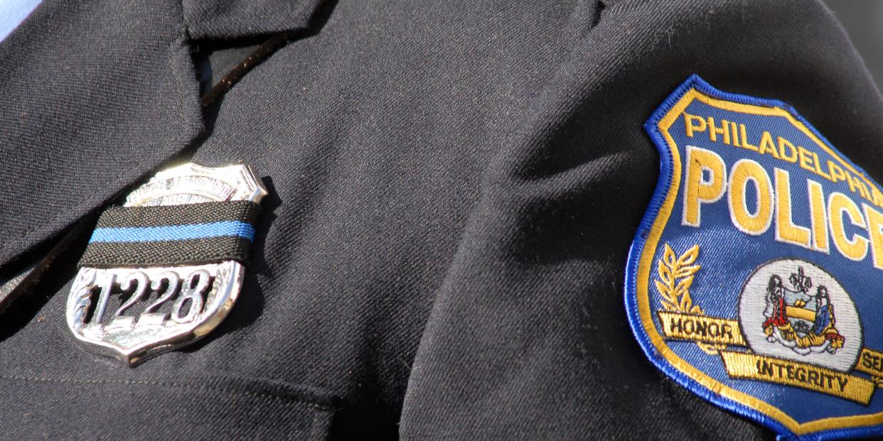 close up of black philadelphia police uniform showing badge and patch
