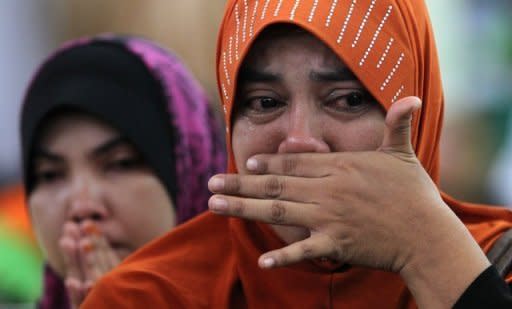 Relatives mourn next to the coffins of people crushed in a landslide in Hulu Langat. A close-knit village on the outskirts of the Malaysian capital was grieving for the deaths of 16 people, mostly children, after an orphanage was hit by a devastating landslide