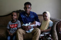 Aden Hussein Hassan with his daughter Asmo, 2 days, son Mohammed, 4, and daughter Adno, pose for a picture inside their apartment in Columbus, Ohio, U.S., August 8, 2018. REUTERS/Shannon Stapleton