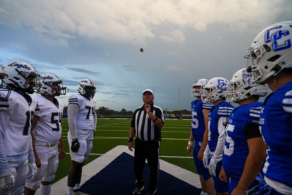 An official tosses the coin ahead of Thursday night's Akins vs. Cedar Creek game at Bastrop ISD Memorial Stadium. Akins won 42-29, the Eagles' first win since Sept. 30, 2021.