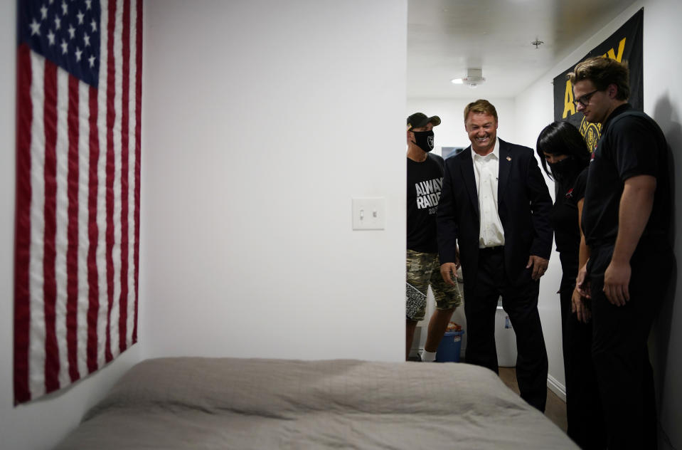 Former U.S. Sen. Dean Heller, second from left, tours the home of Michael Clark, left, at Share Village Las Vegas after announcing a bid for governor of Nevada, Monday, Sept. 20, 2021, in Las Vegas. (AP Photo/John Locher)