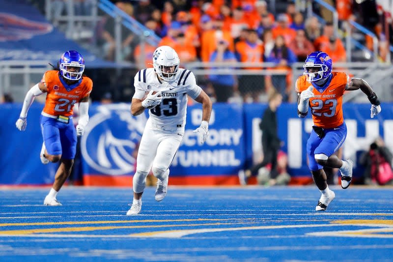 Utah State tight end Josh Sterzer (83) runs in between Boise State safety Zion Washington (21) and safety Seyi Oladipo (23) after a reception in the second half of an NCAA college football game, Saturday, Oct. 5, 2024, in Boise, Idaho. Boise State won 62-30. (AP Photo/Steve Conner) | Steve Conner