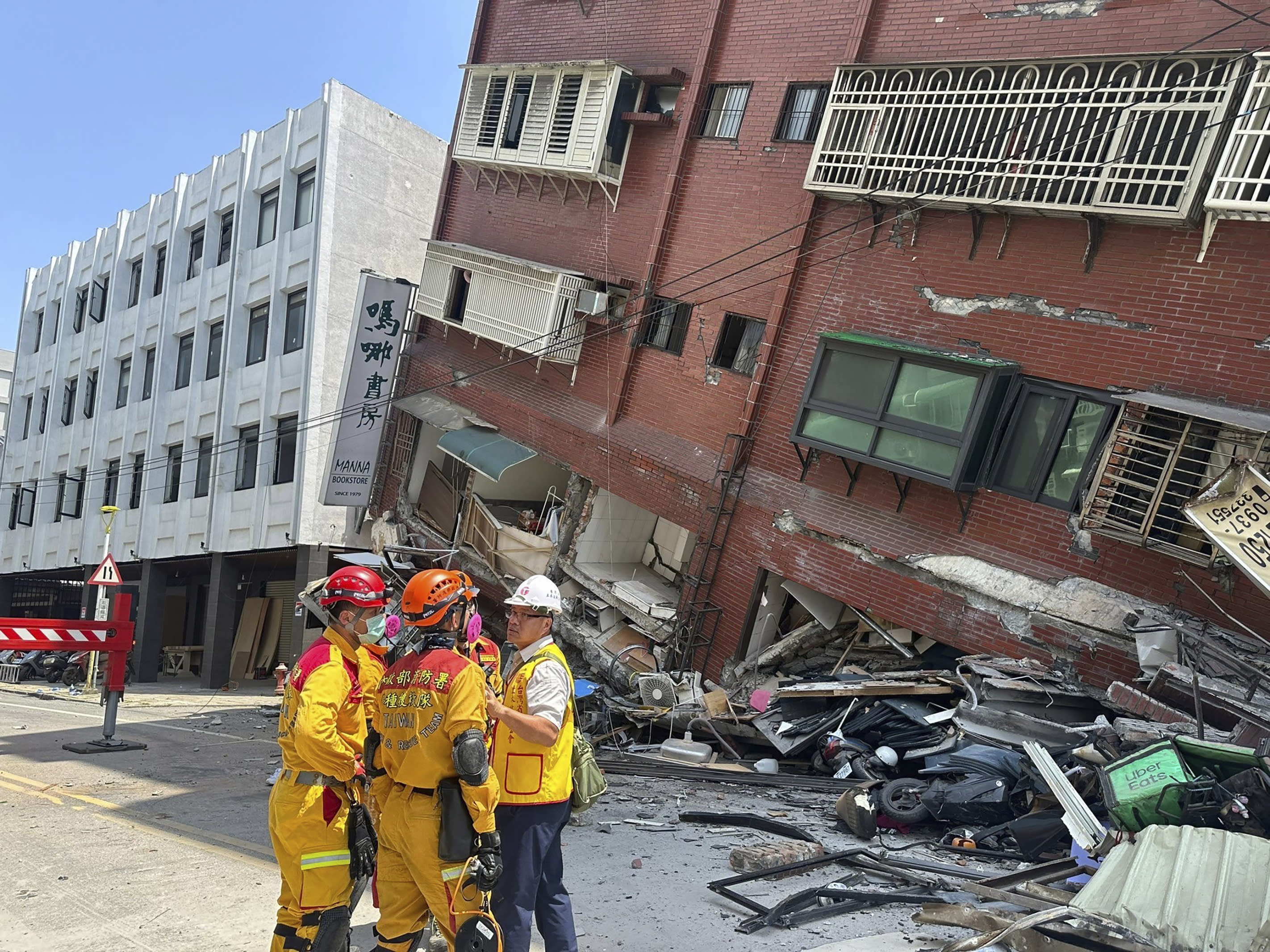 Members of a search and rescue team huddle outside of a leaning building in Hualien City.