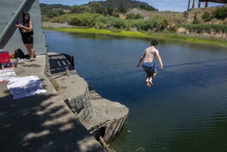 Joseph Lustenberger, 15, jumps off a railroad bridge footing into the Russian River in Healdsburg, Calif.