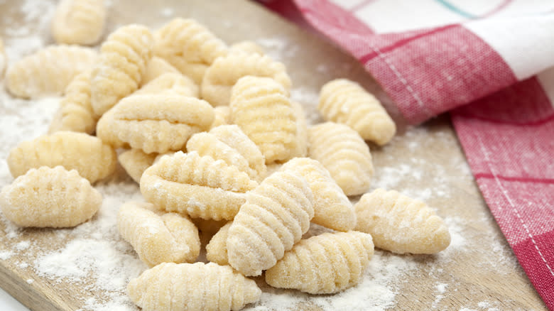 Raw gnocchi on wooden board