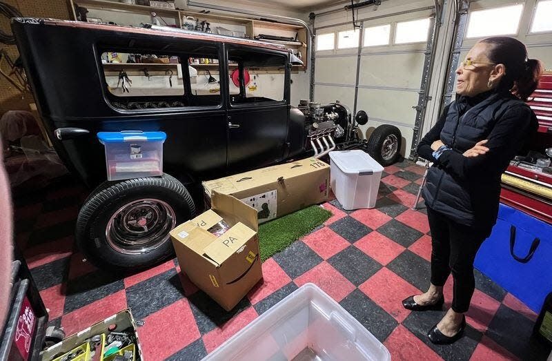 Carmen Navar looks at the hot rod her husband, Richard Cadenhead, was building for her before his death last year. Her son and his friends plan to finish it.