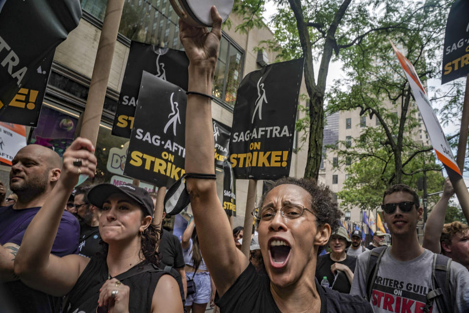 Striking writers and actors chant as they walk a picket line, Friday July 14, 2023, at NBC Universal Studios in New York. The picketing comes a day after the main actors’ union voted to join screenwriters in a double-barreled strike for the first time in more than six decades. The dispute immediately shut down production across the entertainment industry after talks for a new contract with studios and streaming services broke down. (AP Photo/Bebeto Matthews)