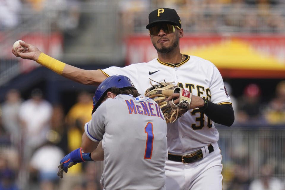 Pittsburgh Pirates shortstop Tucupita Marcano throws to first for a double play after forcing out New York Mets' Jeff McNeil at second base in the sixth inning in a baseball game in Pittsburgh, Saturday, June 10, 2023. (AP Photo/Matt Freed)