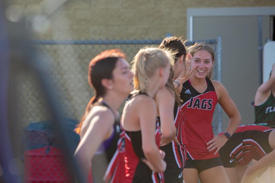 Makenna Topp high-fives a teammate during a 3-way track meet on the Boulder Creek High School track in Anthem on March 29, 2023.
