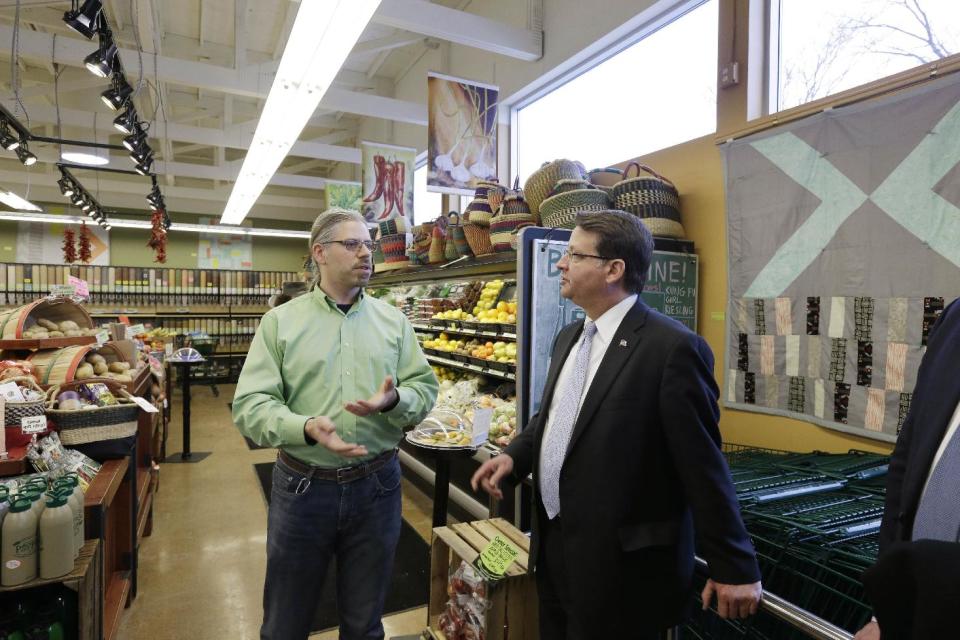 In this Dec. 19, 2013 photo Rep. Gary Peters, right, D-Mich., talks with Chris Dilley, general manager of the People's Food Co-Op, at the store during a campaign stop in conservative Kalamazoo, Mich. In a state where Democratic voter participation has dropped more sharply than Republican in recent midterm contests, Peters is going to a lot of places where his party’s candidates normally don’t go, seeking support from people who don’t normally back Democrats and saying things they might not expect to hear from a Democrat. (AP Photo/Carlos Osorio)