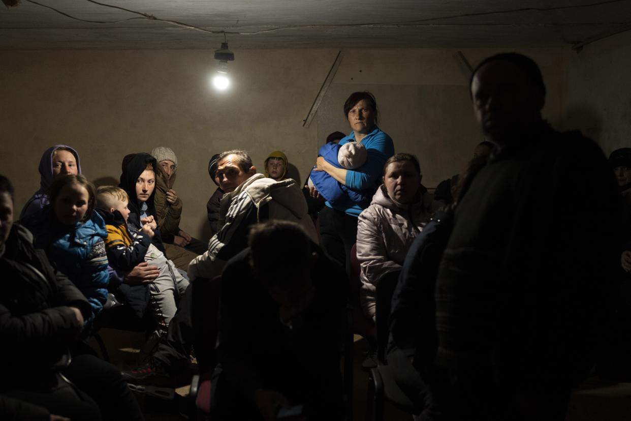 People hide in a basement of a church which is used as a bomb shelter, after fleeing from nearby villages, that have been attacked by the Russian army, in the town of Bashtanka, Mykolaiv district, Ukraine, on Thursday, March 31, 2022. (AP Photo/Petros Giannakouris)