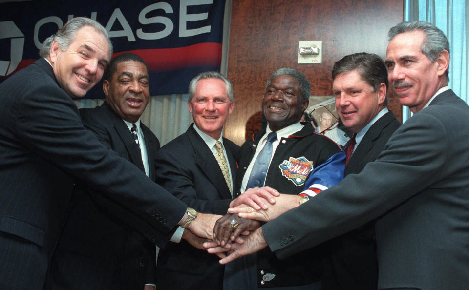 CORRECTS THAT HARRELSON DIED EARLY THURSDAY, JAN. 11, NOT WEDNESDAY NIGHT, JAN. 10, AS ORIGINALLY SENT -FILE - Six members of the 1969 World Series-champion New York "Miracle Mets," from left, first baseman Ed Kranepool, outfielder Tommy Agee, shortstop Bud Harrelson, third baseman Ed Charles, pitcher Tom Seaver and outfielder Art Shamsky pile up their hands as they show off their World Series rings at a news conference in New York, Dec. 10, 1998. Bud Harrelson, the scrappy and sure-handed shortstop who fought Pete Rose on the field during a playoff game and helped the New York Mets win an astonishing championship, died early Thursday, Jan. 11, 2024. He was 79. The Mets said Thursday morning that Harrelson died at a hospice house in East Northport, New York after a long battle with Alzheimer's. (AP Photo/Marty Lederhandler, File)