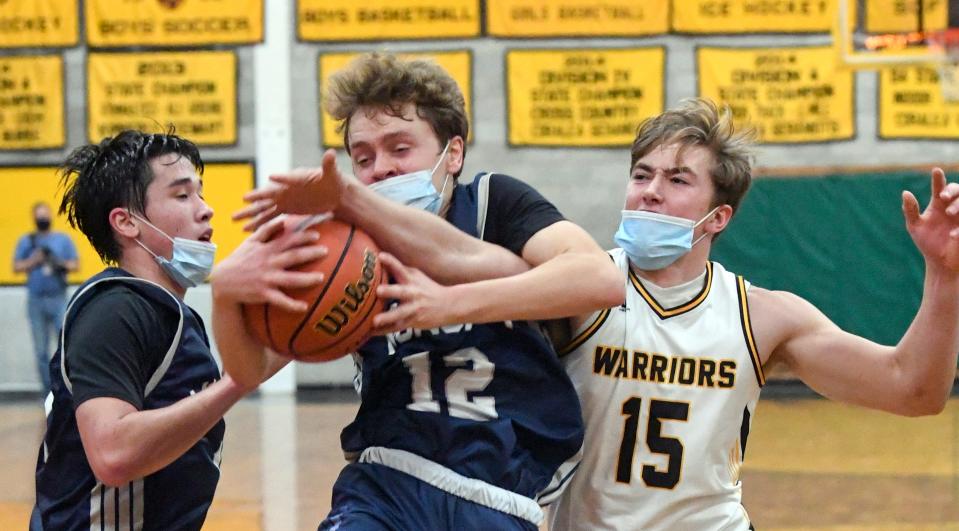 Dillon White of Nauset reaches in on Finn Hyora of Monomoy in this December 2021 game.