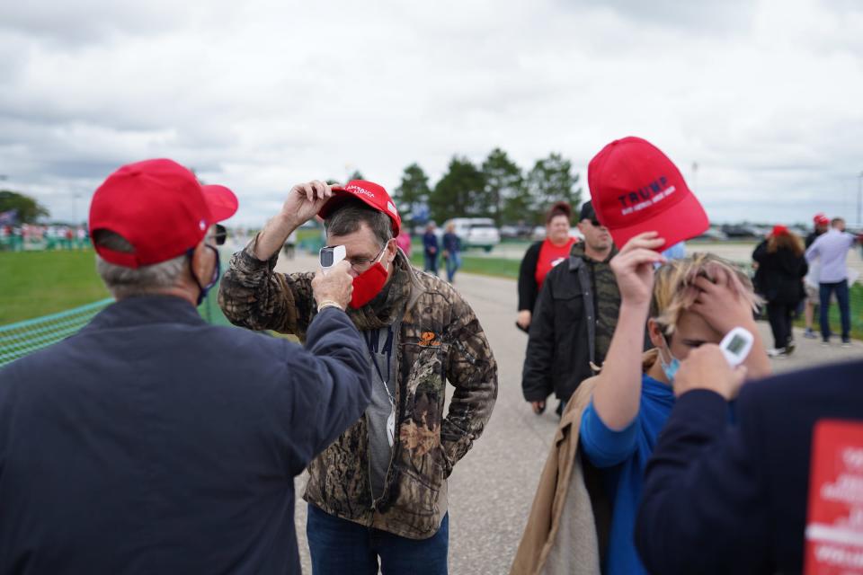 People have their temperature checked while waiting to hear President Donald Trump speak during a campaign stop at Avflight Saginaw in Freeland on Thursday, September 10, 2020.