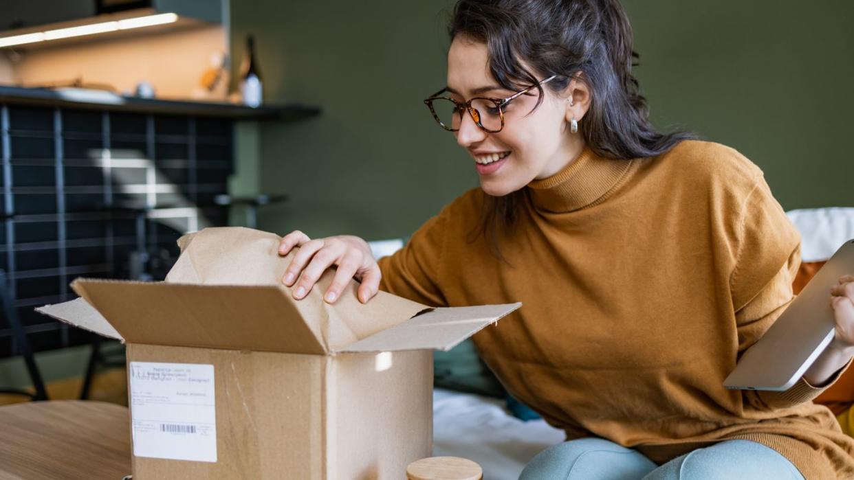 smiling woman opening a delivery box