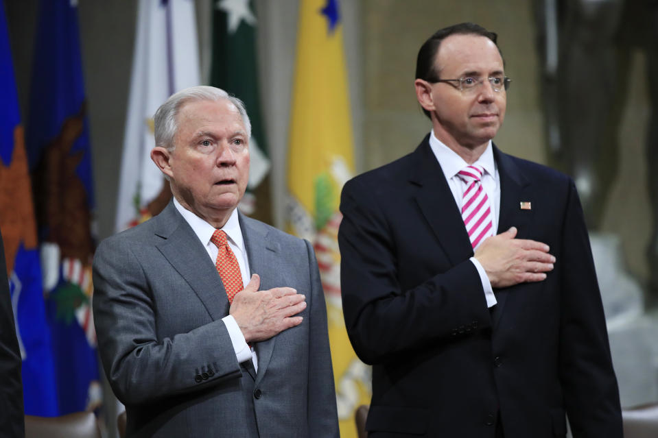 Attorney General Jeff Sessions, left, and Deputy Attorney General Rod Rosenstein, put their hands over their heart as they sing the National Anthem during a Religious Liberty Summit at the Department of Justice, Monday, July 30, 2018. Sessions says there’s a “dangerous movement” to erode protections for Americans to worship and believe as they choose. (AP Photo/Manuel Balce Ceneta)