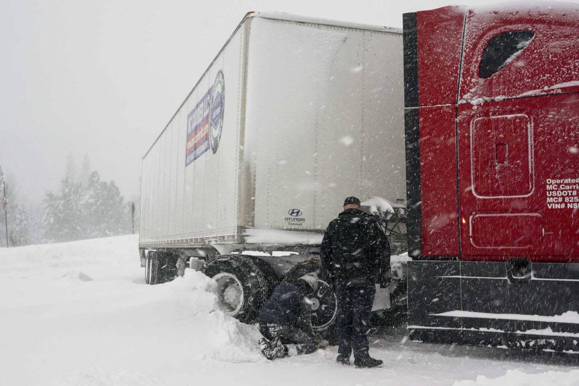 Chains are installed on a big rig’s tires during a storm, Saturday, March 2, 2024, in Truckee, Calif. A powerful blizzard howled Saturday in the Sierra Nevada as the biggest storm of the season shut down a long stretch of Interstate 80 in California and gusty winds and heavy rain hit lower elevations, leaving tens of thousands of homes without power. Brooke Hess-Homeier/AP