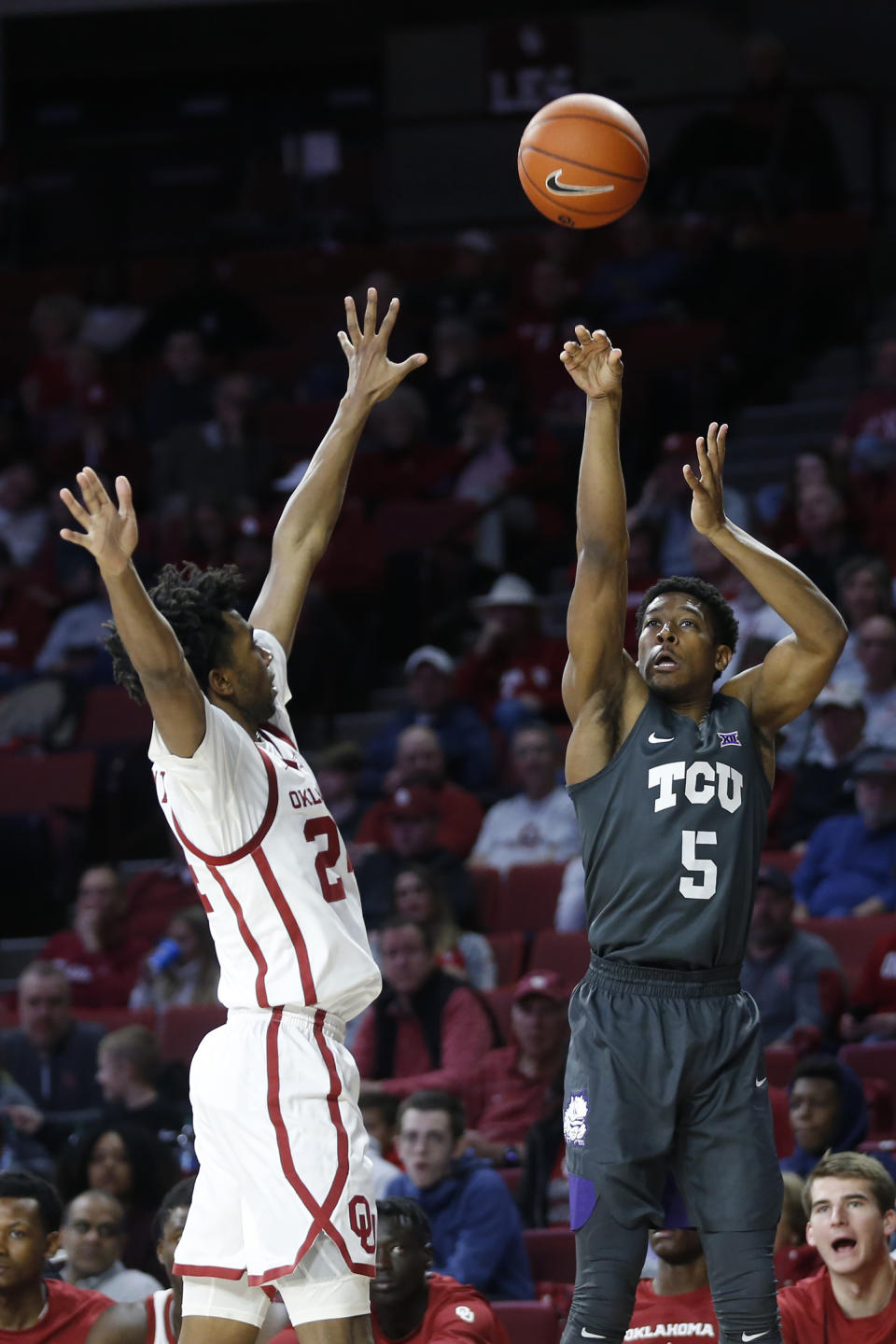 TCU's Jaire Grayer (5) takes a shot over Oklahoma's Jamal Bieniemy (24) during the first half of an NCAA college basketball game in Norman, Okla., Saturday, Jan. 18, 2020. (AP Photo/Garett Fisbeck)