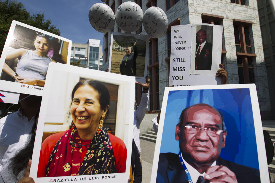 Demonstrators hold pictures of the plane crash victims during a vigil on the six-month anniversary of the crash of a Boeing 737 Max 8, killing 157 people, in Ethiopia on March 10, which has resulted in the grounding hundreds of the planes worldwide, outside of the Department of Transportation, Tuesday, Sept. 10, 2019 in Washington. (AP Photo/Jose Luis Magana)