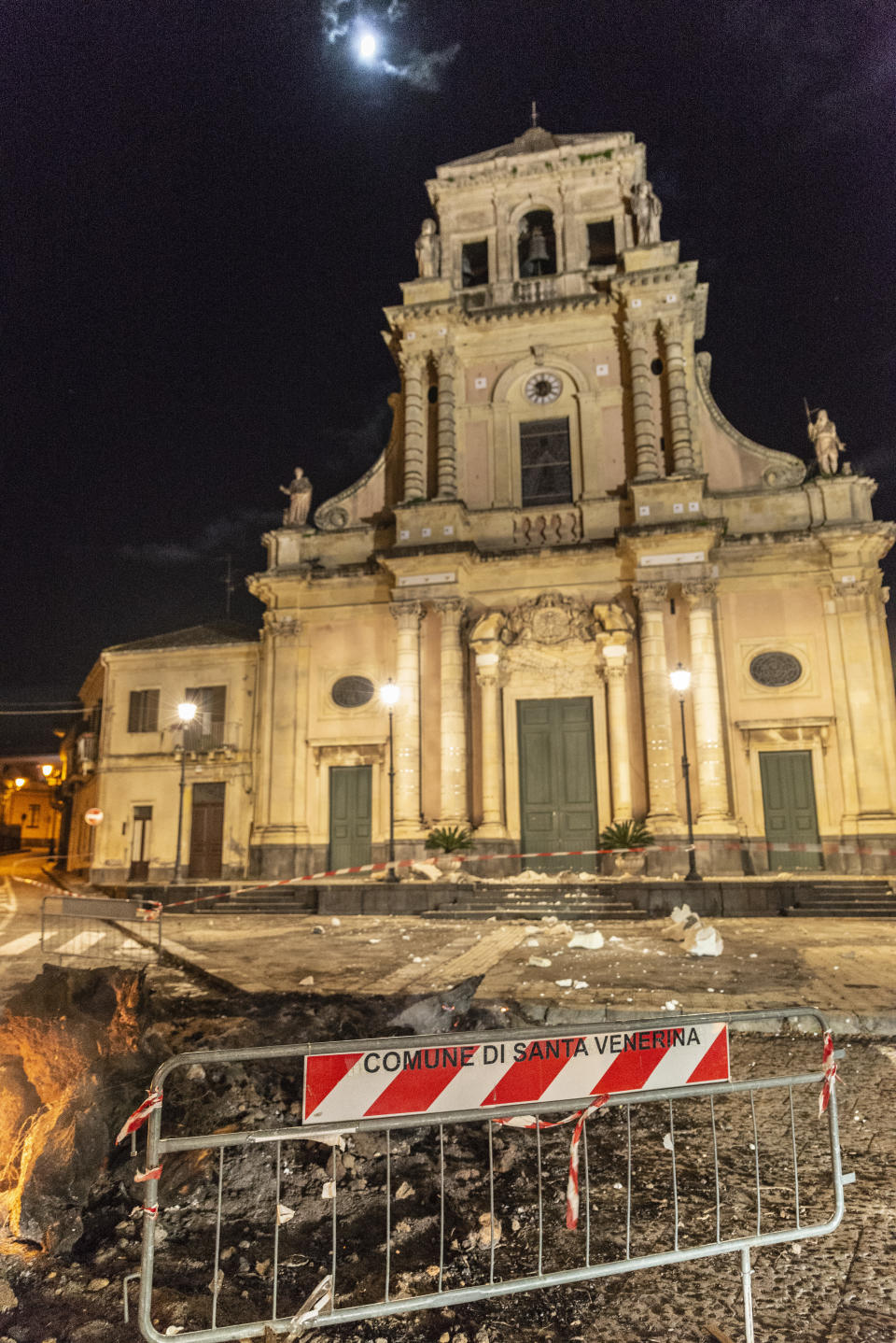 Debris stand in front of the damaged Sacro Cuore (Holy Heart) Church in Santa Venerina, Sicily Italy, Wednesday, Dec. 26, 2018. A quake triggered by Italy's Mount Etna volcano has jolted eastern Sicily, slightly injuring 10 people and prompting frightened Italian villagers to flee their homes. (AP Photo/Salvatore Allegra)