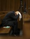 Olympic and Paralympic track star Oscar Pistorius holds his head in his hands, in the dock during his trial for the murder of his girlfriend Reeva Steenkamp, at the North Gauteng High Court in Pretoria, March 10, 2014. Pistorius is on trial for murdering his girlfriend Reeva Steenkamp at his suburban Pretoria home on Valentine's Day last year. He says he mistook her for an intruder. "Blade Runner" Pistorius broke down on Monday when the South African court heard details from the autopsy of Steenkamp. REUTERS/Siphiwe Sibeko (SOUTH AFRICA - Tags: CRIME LAW ENTERTAINMENT SPORT ATHLETICS)