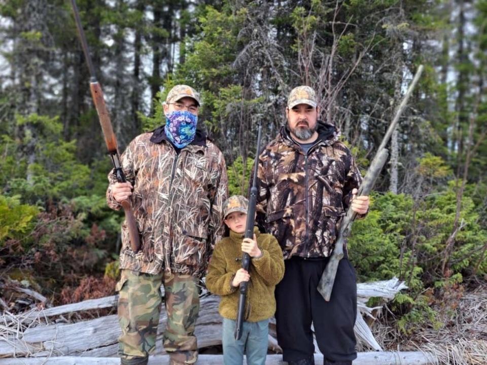 Yoanick Dion, right, poses with two of his family members during a hunt near Oujé-Bougoumou, Que. His hunting camp is threatened by fires there.  (Submitted by Yoanick Dion - image credit)