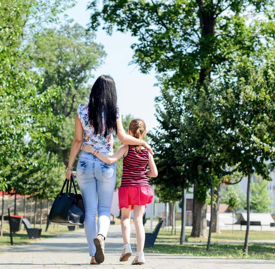 Mother and daughter walking in park (Getty Images)
