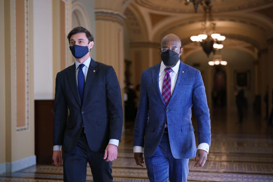 Sen. Jon Ossoff, D-Ga., left, and Sen. Raphael Warnock, D-Ga., leave the chamber just after the Senate narrowly approved a $1.9 trillion COVID-19 relief bill, at the Capitol in Washington, March 6, 2021.