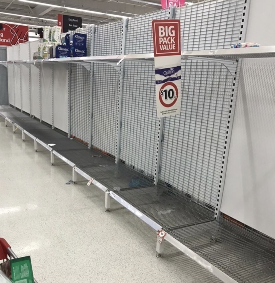 Toilet paper shelves inside an Adelaide Coles shown bare.