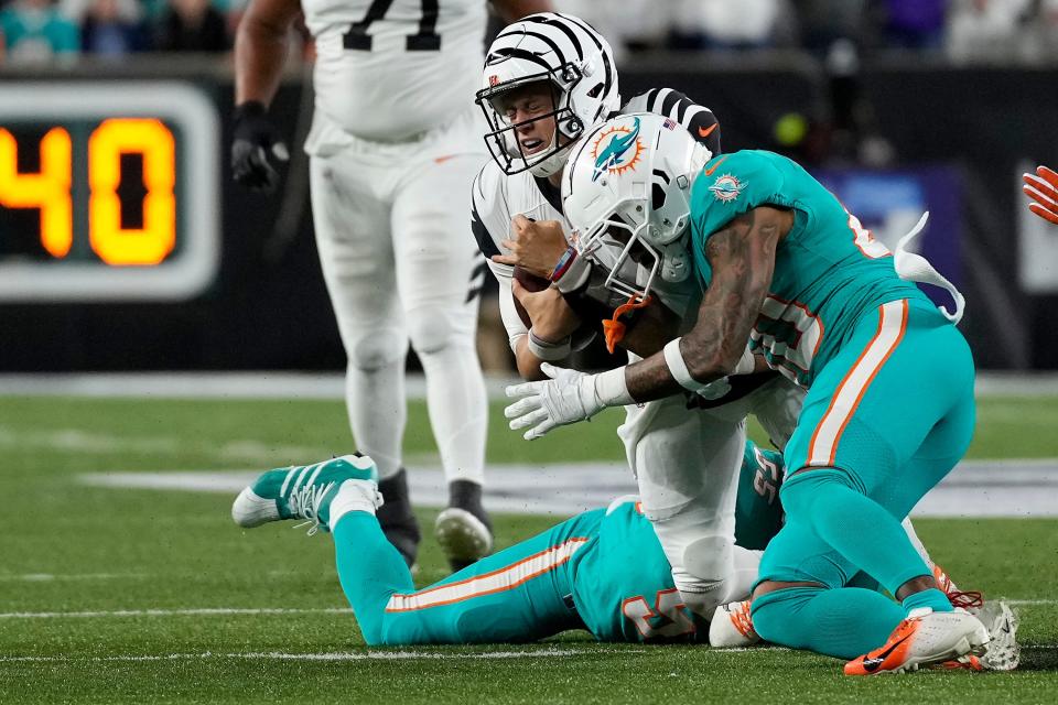 Cincinnati Bengals quarterback Joe Burrow takes a hit from Miami Dolphins linebacker Channing Tindall on Sept. 29.