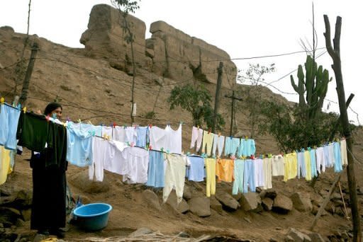 A woman hangs clothes to dry in her backyard, which forms part of the Puruchuco archaeological site in Lima. Huacas "for the most part are not protected, which is why they have been invaded by families without homes, or turned into dumps or refuges for delinquents," archeologists says