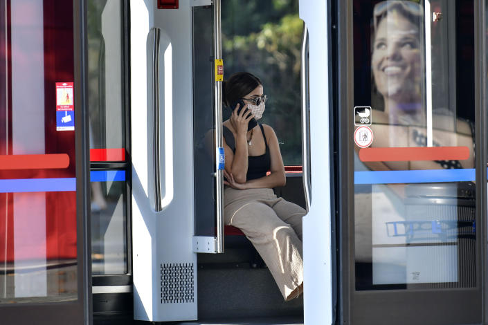 A passenger wears a face mask at a tram in Gelsenkirchen, Germany, Wednesday, Aug. 12, 2020. To avoid the outspread of the coronavirus wearing a mask is mandatory at all public transport. (AP Photo/Martin Meissner)