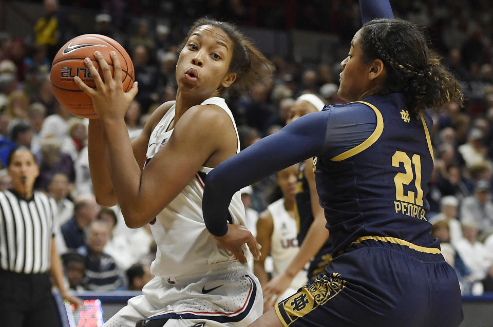 Connecticut's Megan Walker, left, is guarded by Notre Dame's Anaya Peoples, right, in the second half of an NCAA college basketball game, Sunday, Dec. 8, 2019, in Storrs, Conn. (AP Photo/Jessica Hill)