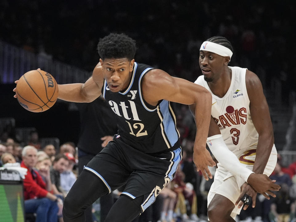 Atlanta Hawks forward De'Andre Hunter (12) gets past Cleveland Cavaliers guard Caris LeVert (3) during the first half of an NBA basketball game Wednesday, March 6, 2024, in Atlanta. (AP Photo/John Bazemore)