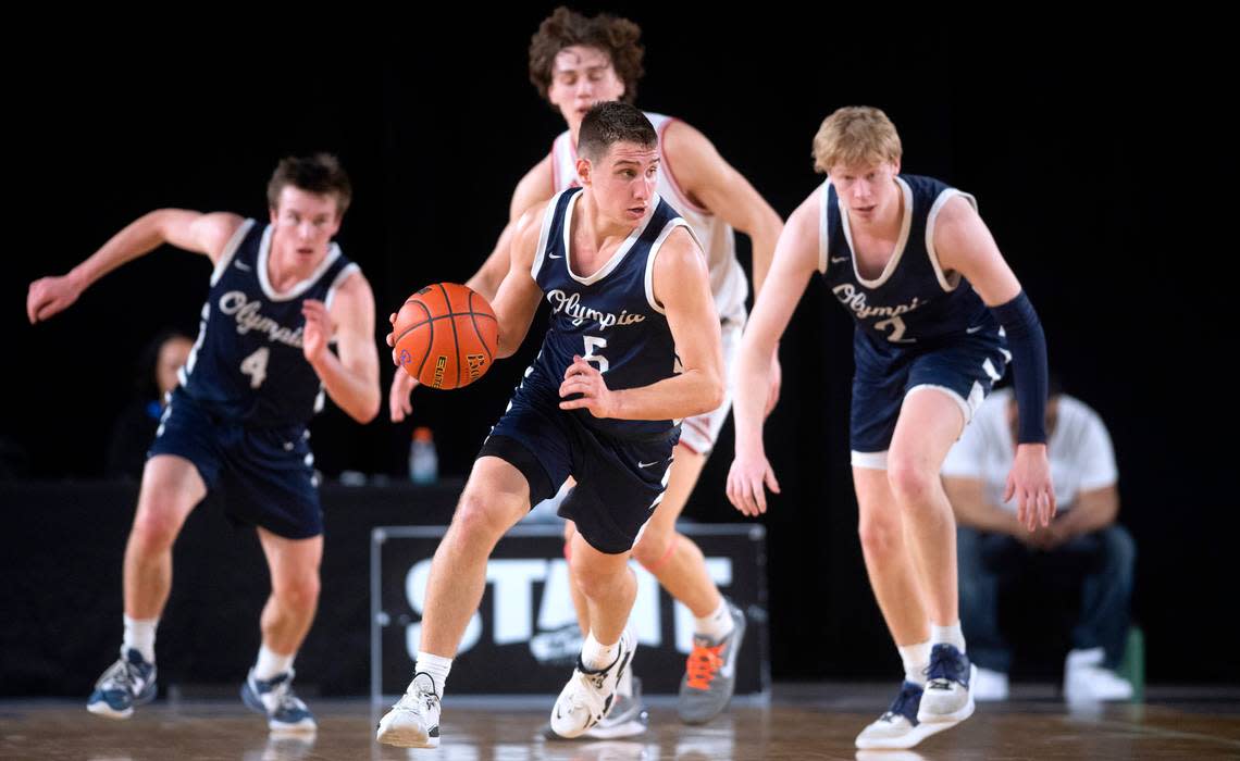 Olympia’s Mason Juergens pushes the ball up court in front of teammates Matt Lindblom (4) and Andreas Engholm during their state semifinal game against the Mount Si Wildcats at the WIAA state basketball tournament in the Tacoma Dome in Tacoma, Washington, on Friday, March 3, 2023.