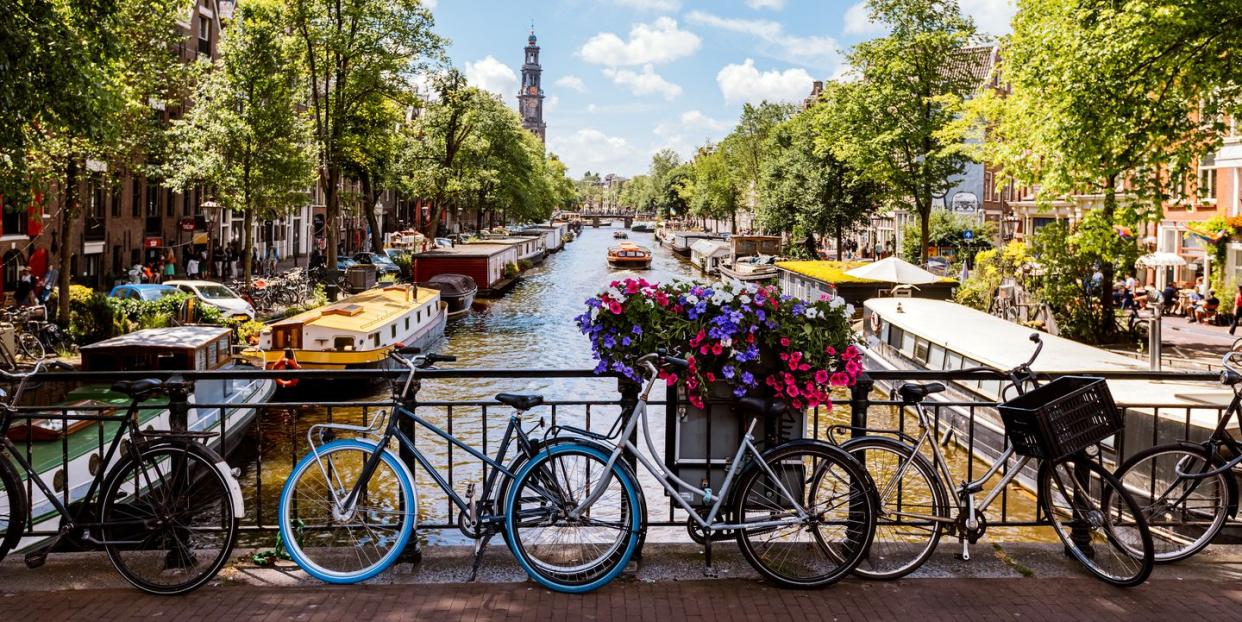 bikes by the canal on a sunny summer day in amsterdam, netherlands