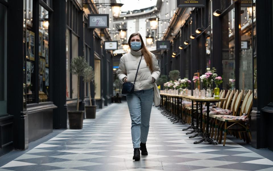 CARDIFF, UNITED KINGDOM - MARCH 17: A woman walks through an empty Castle Arcade wearing a surgical mask on March 17, 2020 in Cardiff, Wales. Boris Johnson held the first of his public daily briefing on the Coronavirus outbreak yesterday and told the public to avoid theatres, going to the pub and work from home where possible. The number of people infected with COVID-19 in the UK reached 1500 today with 36 deaths. (Photo by Matthew Horwood/Getty images) - Matthew Horwoo/Getty Images