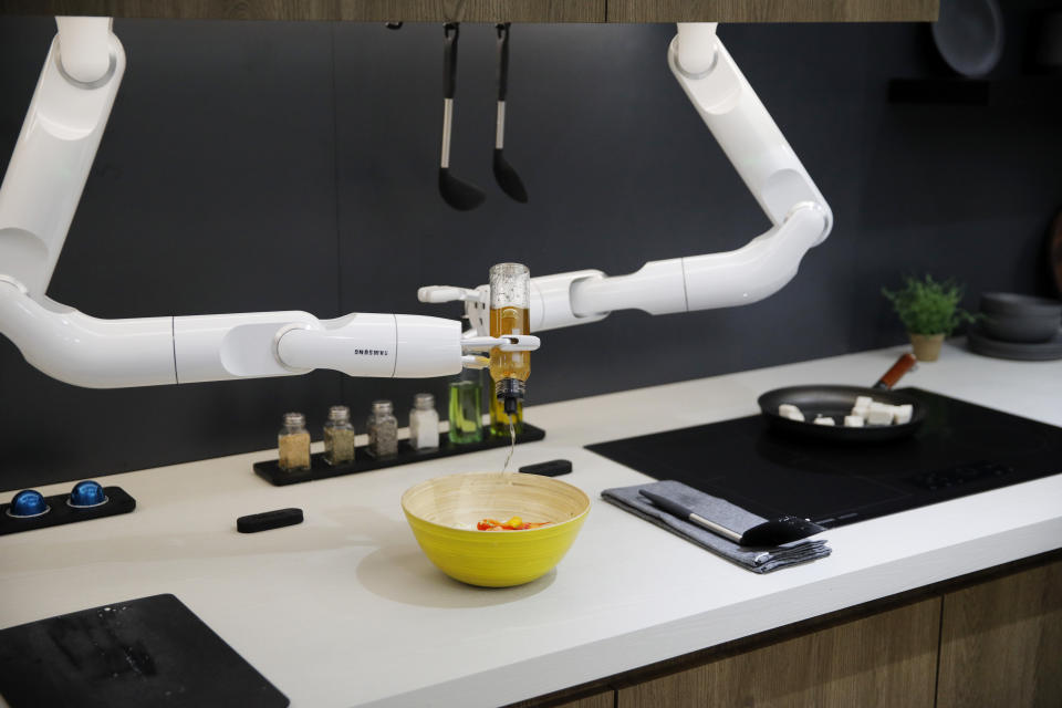 The Bot Chef pours dressing into a salad during a demonstration at the Samsung booth during the CES tech show, Tuesday, Jan. 7, 2020, in Las Vegas. The robot is designed to help with cooking tasks, not to make a meal all on it's own. (AP Photo/John Locher)