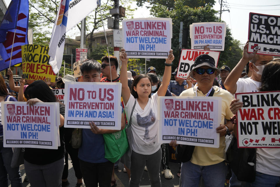 Protesters hold slogans against the visit of U.S. Secretary of State Antony Blinken during a rally near the Malacanang presidential palace in Manila, Philippines on Tuesday, March 19, 2024. (AP Photo/Aaron Favila)