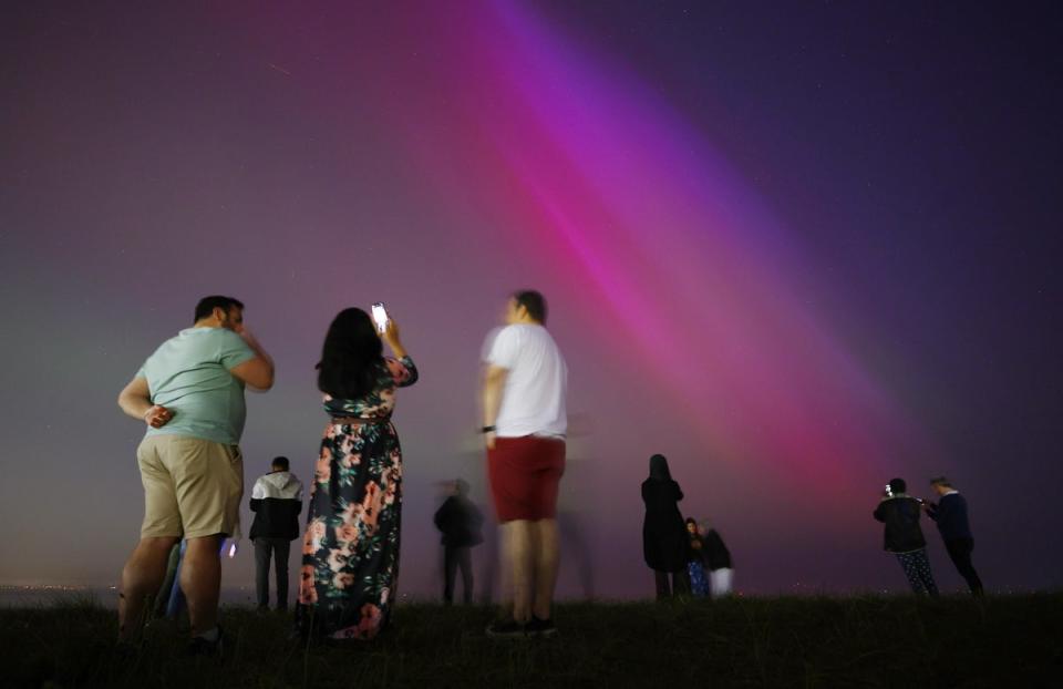 People gather at Crosby Beach to look at the Northern Lights (EPA)
