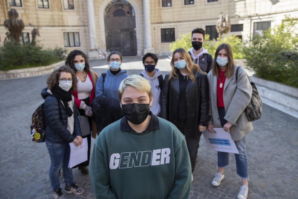 Matteo Coccimiglio poses for a photos with his schoolmates in front of the Ripetta art school in Rome, Wednesday, March 24, 2021. Matteo is an 18-year-old student who identifies as a man and is in the process of changing his legal gender from female to male. The Ripetta school of art in Rome - where he studies - recently joined a handful of high schools in Italy that give transgender students the right to be known by a name other than the one they were given at birth. The initiative is meant to create an environment where transgender students feel secure and reflects a growing awareness in Italy of gender dysphoria among teenagers and children. (AP Photo/Alessandra Tarantino)