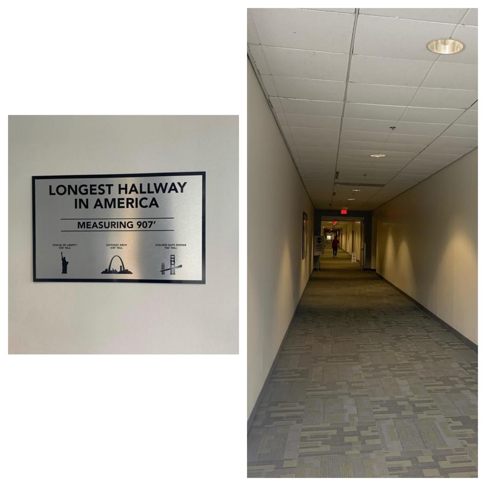 A long hallway with a sign at the start of it saying "Longest Hallway in America / Measuring 907 feet"