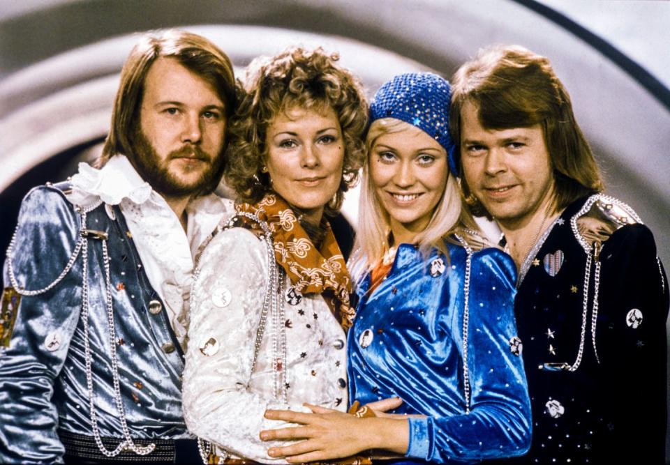 benny andersson, anni frid lyngstad, agnetha faltskog and bjorn ulvaeus smile and pose for a photo while standing next to each other