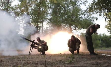 Members of the Ukrainian armed forces fire a grenade launcher, following what servicemen said was a shooting attack from the positions of fighters of the separatist self-proclaimed Donetsk People's Republic, in Avdiivka in Donetsk region, Ukraine, June 18, 2015. REUTERS/Maksim Levin