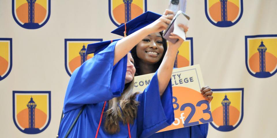 Friends Jennifer Teope, 35, left, and Neazha Cooley, 24, both among the first graduates of Erie County Community College, take selfies prior to the graduation ceremony.