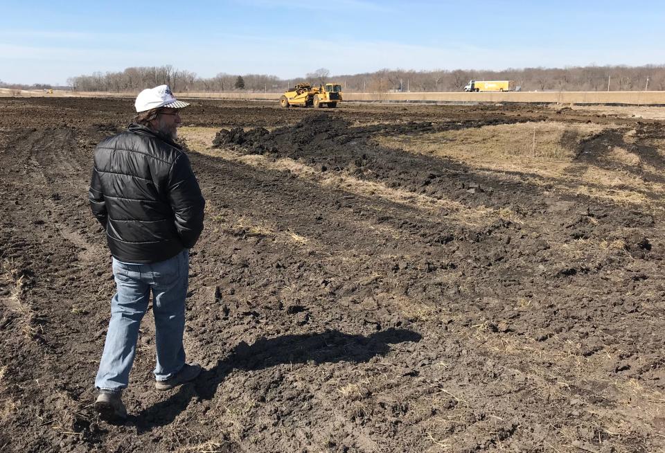 As crews from Milestone Contractors work in the background, Eric Erskin walks the freshly graded dirt of the 20 acres of what will become Abby & Libby Memorial Park, near the corner of the Hoosier Heartland Highway and Indiana 218, a mile north of Delphi, on Wednesday, March 27, 2019. The park will be a memorial to Abby Williams and Libby German, two Delphi eighth-graders murdered while hiking a popular community trail near Delphi on Feb. 13, 2017. Erskin is Williams' grandpa.