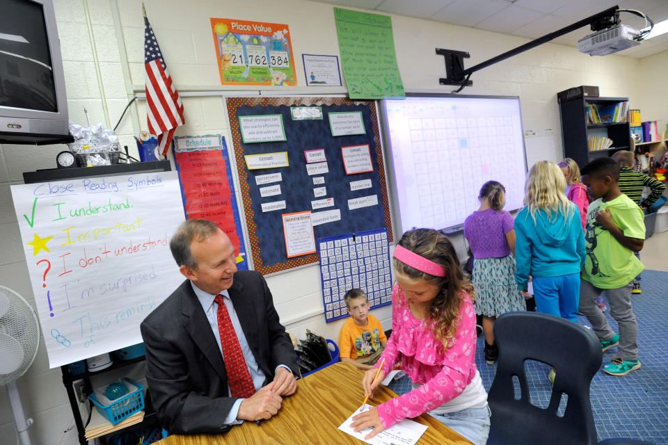 Delaware Gov. Jack Markell, left, helps third-grader Raegan Megahan with a math lesson at Silver Lake Elementary School in Middletown, Del., Tuesday, Oct. 1, 2013. Silver Lake has begun implementing the national Common Core State Standards for academics. (AP Photo/Steve Ruark)